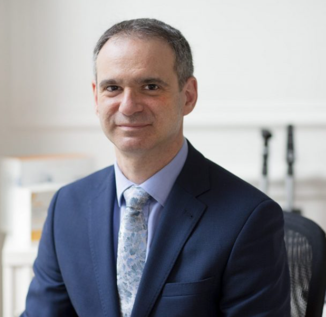 Professor Michel Michaelides from UCL. He wears a dark blue suit and a tie.