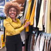 A woman smiling while she looks through a clothing rail at one of our shops