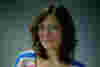 Josie has dark shoulder lenth hair. She has a big smile and wears a stripey jumper reflecting her sunny disposition.