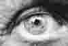 Extreme close up of an eye in black and white. The lines around the eye imply it belongs to someone of an older age.