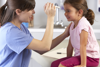 Clinician shining torch into child's eye