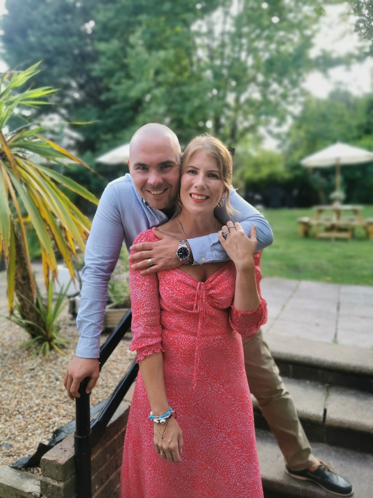 Husband and wife team Matt and Amy Tait in a garden with the arms around each other