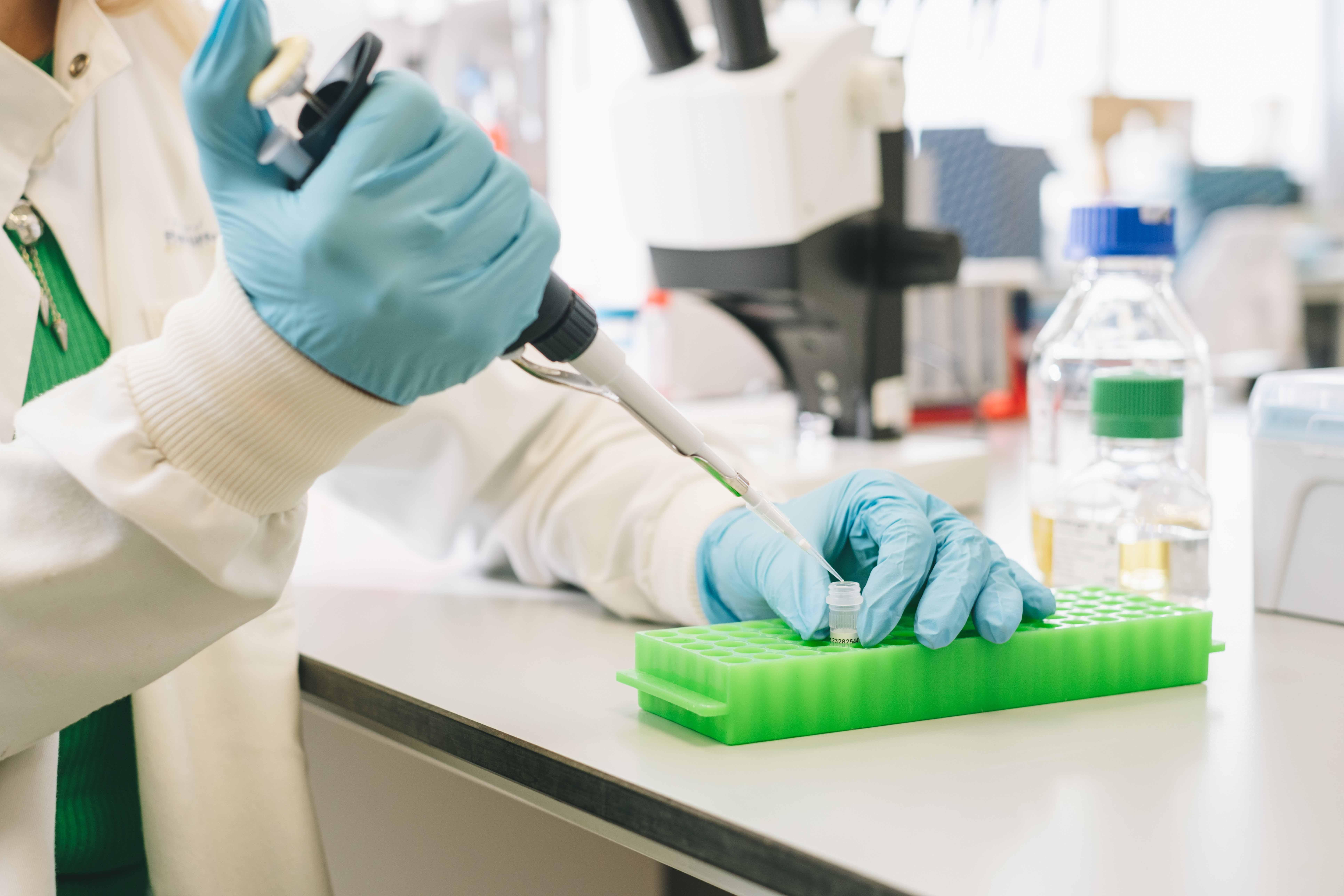Researcher hands holding a pipette and test tube