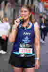 Fight for Sight supporter Amy is biting her medal after completing the London Marathon