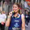 Fight for Sight supporter Amy is biting her medal after completing the London Marathon