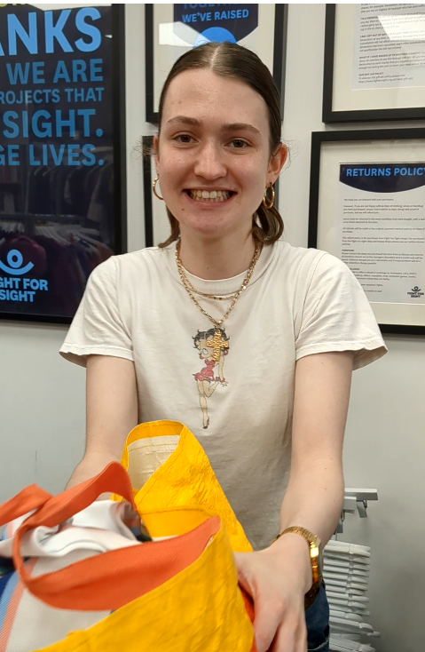 Volunteer Evie accepting a bag of donations in our West Norwood Fight for Sight charity shop
