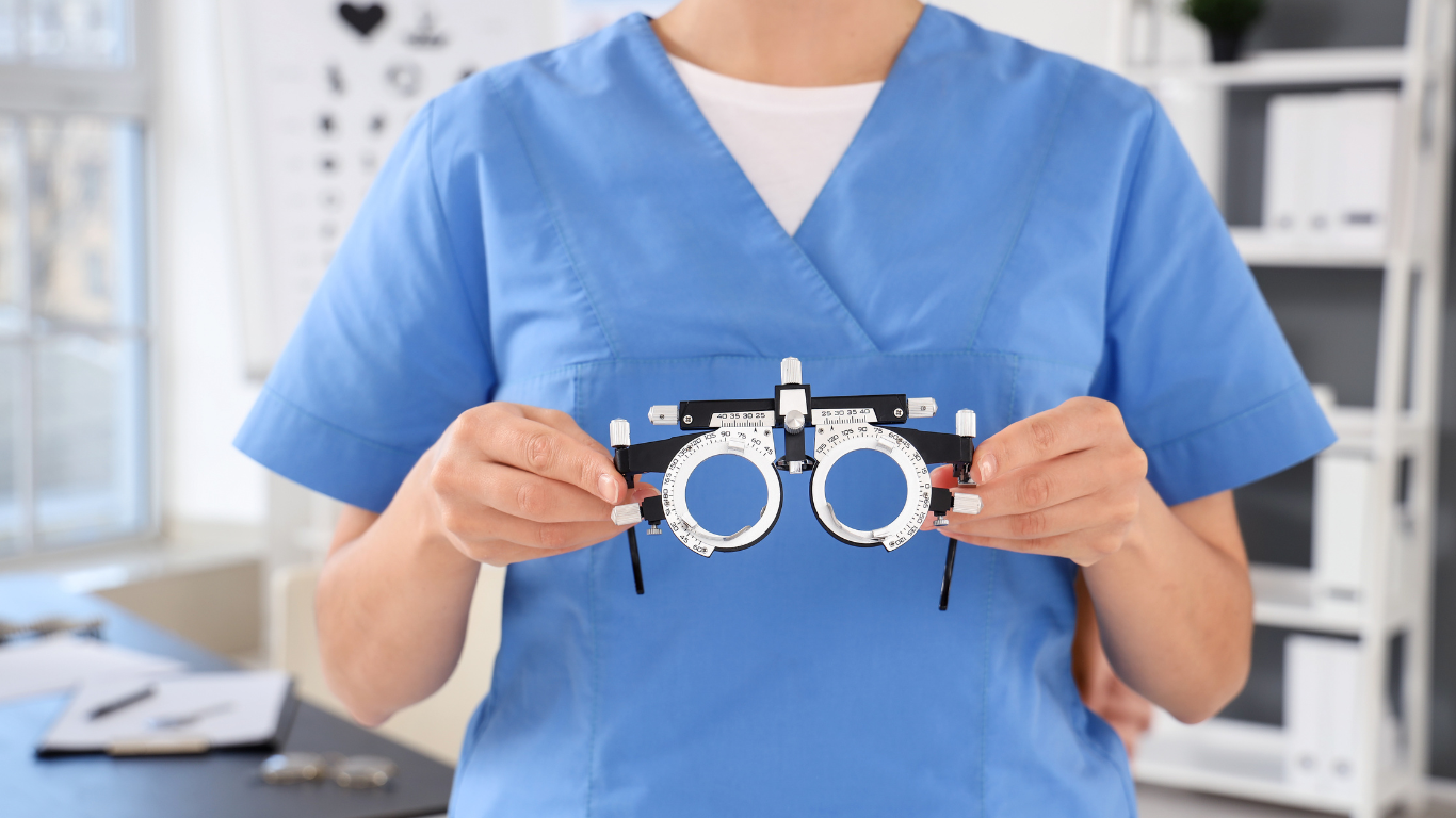 An optometrist holding glasses used in a refraction test.