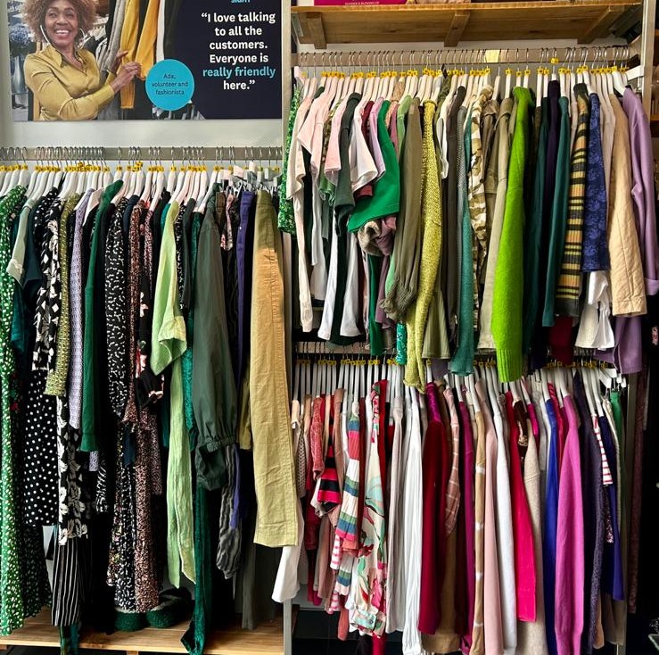 Green clothes rail in a Fight for Sight charity shop
