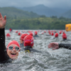 Swimmers in open water, one swimmer turned back to camera smiling and waving