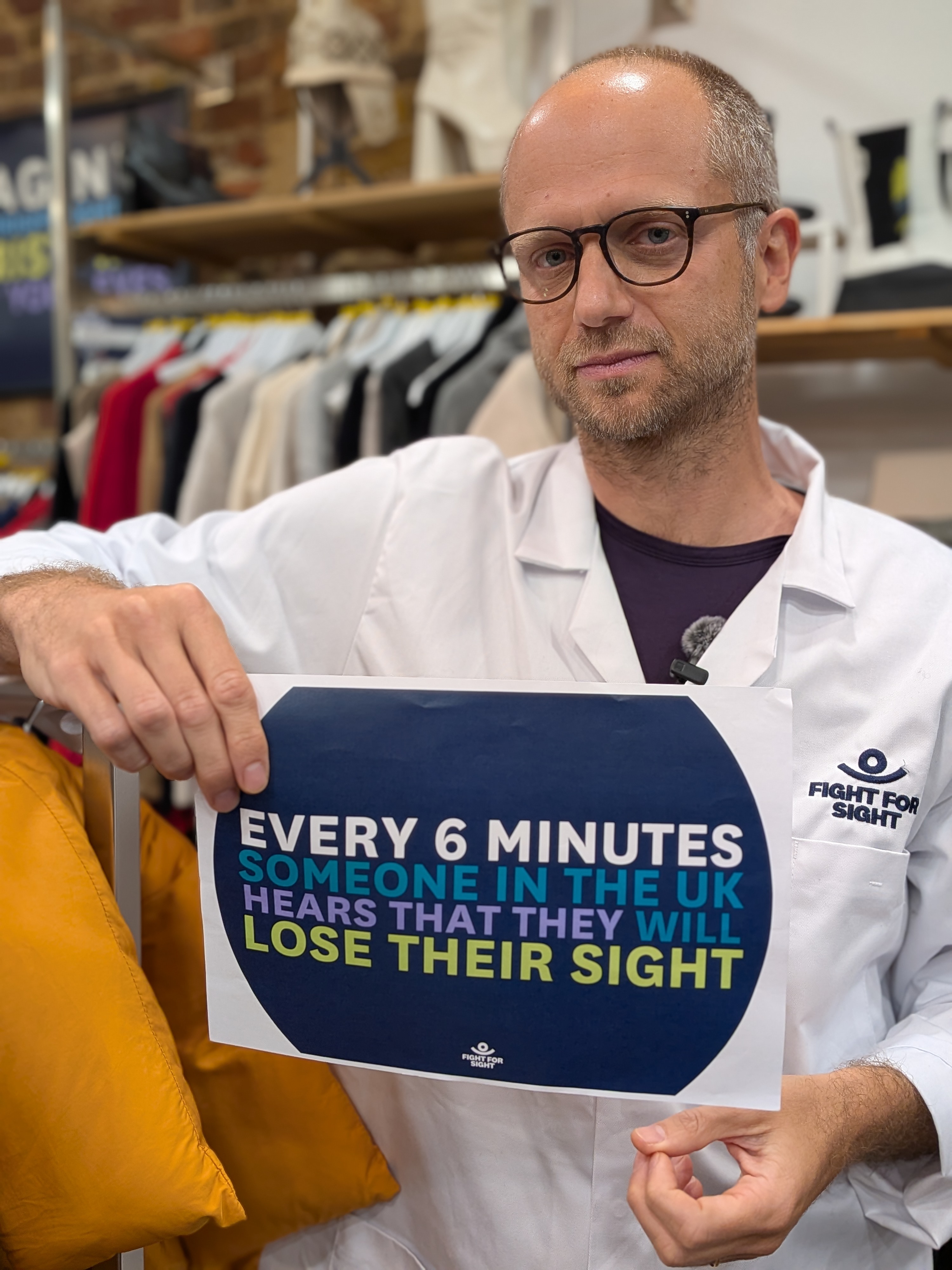 Matteo Rizzi Fight for Sight researcher holding a sign that says Every Six Minutes Someone In the UK Hears They Will Lose their sight