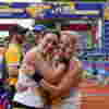 Runners celebrating and embracing after crossing the finish line of the Rob Burrow Leeds Marathon