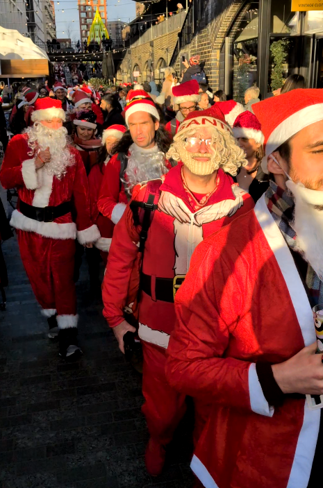 SantaCon at the Fight for Sight Coal Drops Yard Christmas Popup with lots of people dressed as Santa near Kings Cross
