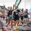 A Fight for Sight supporter smiling and waving while running over Tower Bridge in the London Marathon