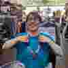 Louis in Chiswick charity shop in Fight for Sight tshirt laughing wearing a donation necklace