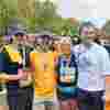 A group of four people who just took part in the royal parks half marathon. they are all smiling after having taken part! 