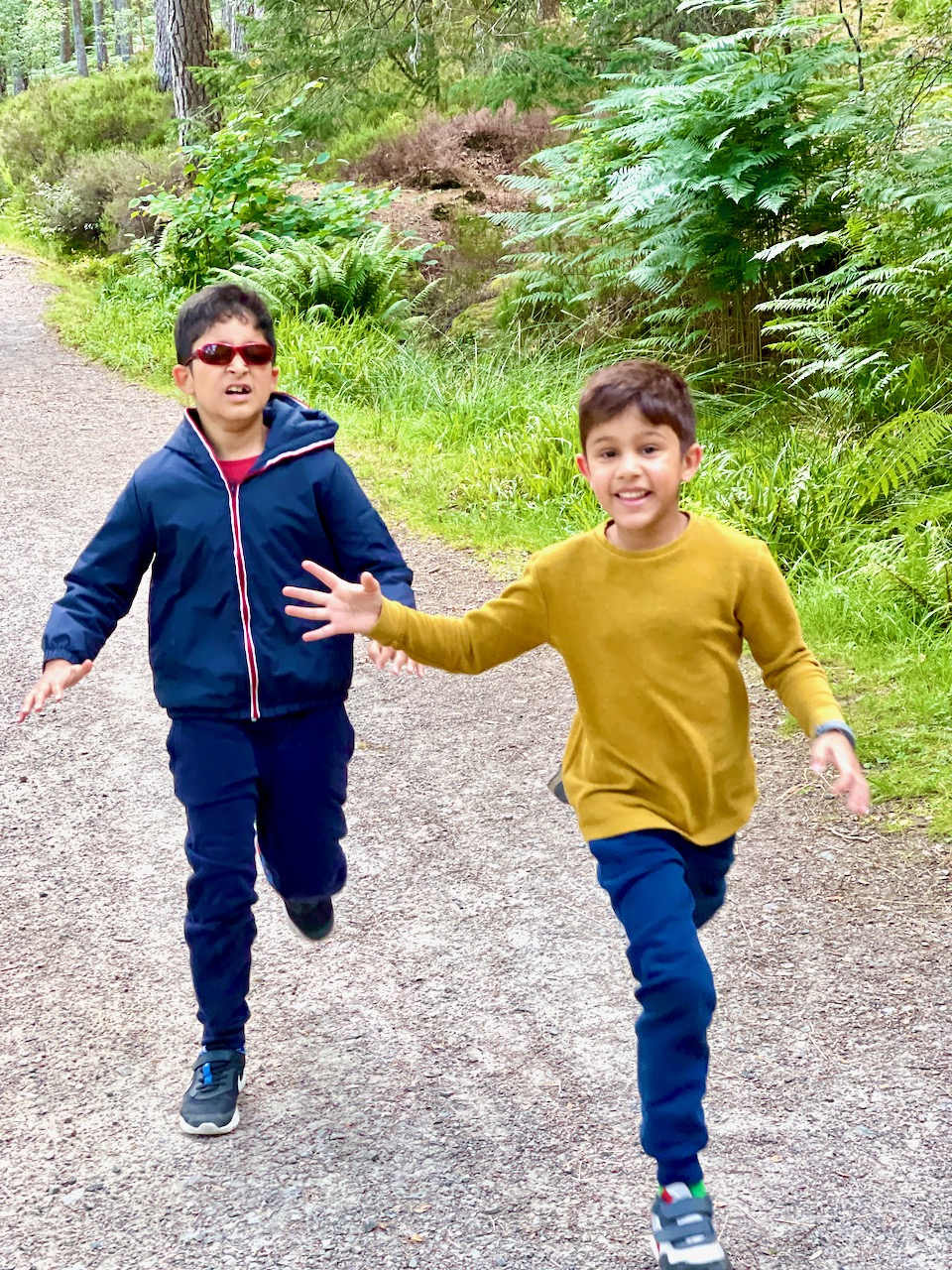 Avi Krishnan and his brother Aarav running. Avi wears tinted glasses as he is photophobic due to his achromatopsia