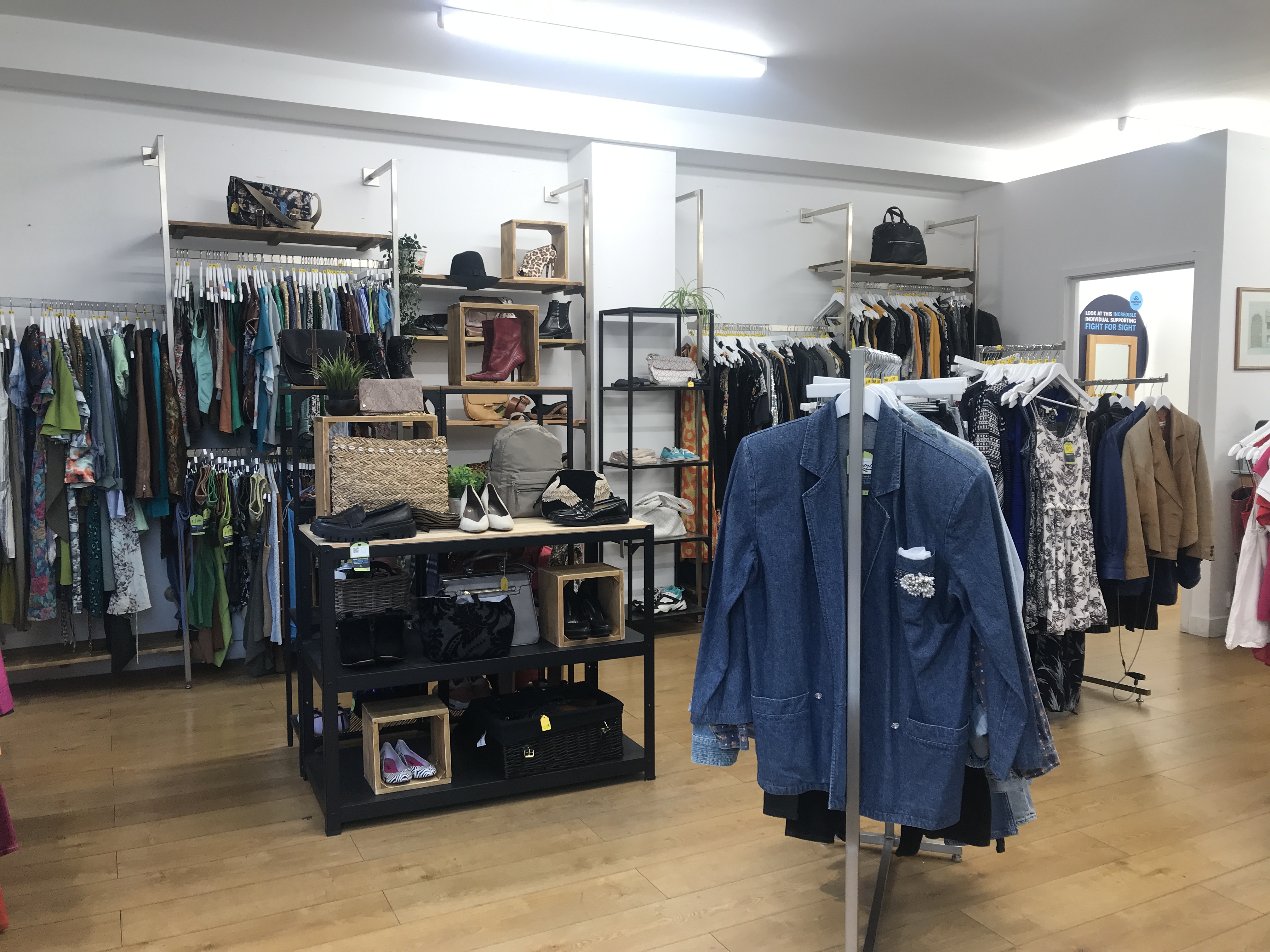 The interior of our Portobello Road shop. Rails of men and womenswear as well as a display of shoes and bags can be seen.