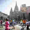 Runners taking part in the Barcelona Marathon and passing the Sagrada Familia