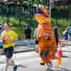 Person running in an inflatable dinosaur costume