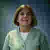 A picture of Monica Smith - she wears a light green cardigan and has shoulder-length hair. 