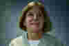 A picture of Monica Smith - she wears a light green cardigan and has shoulder-length hair. 