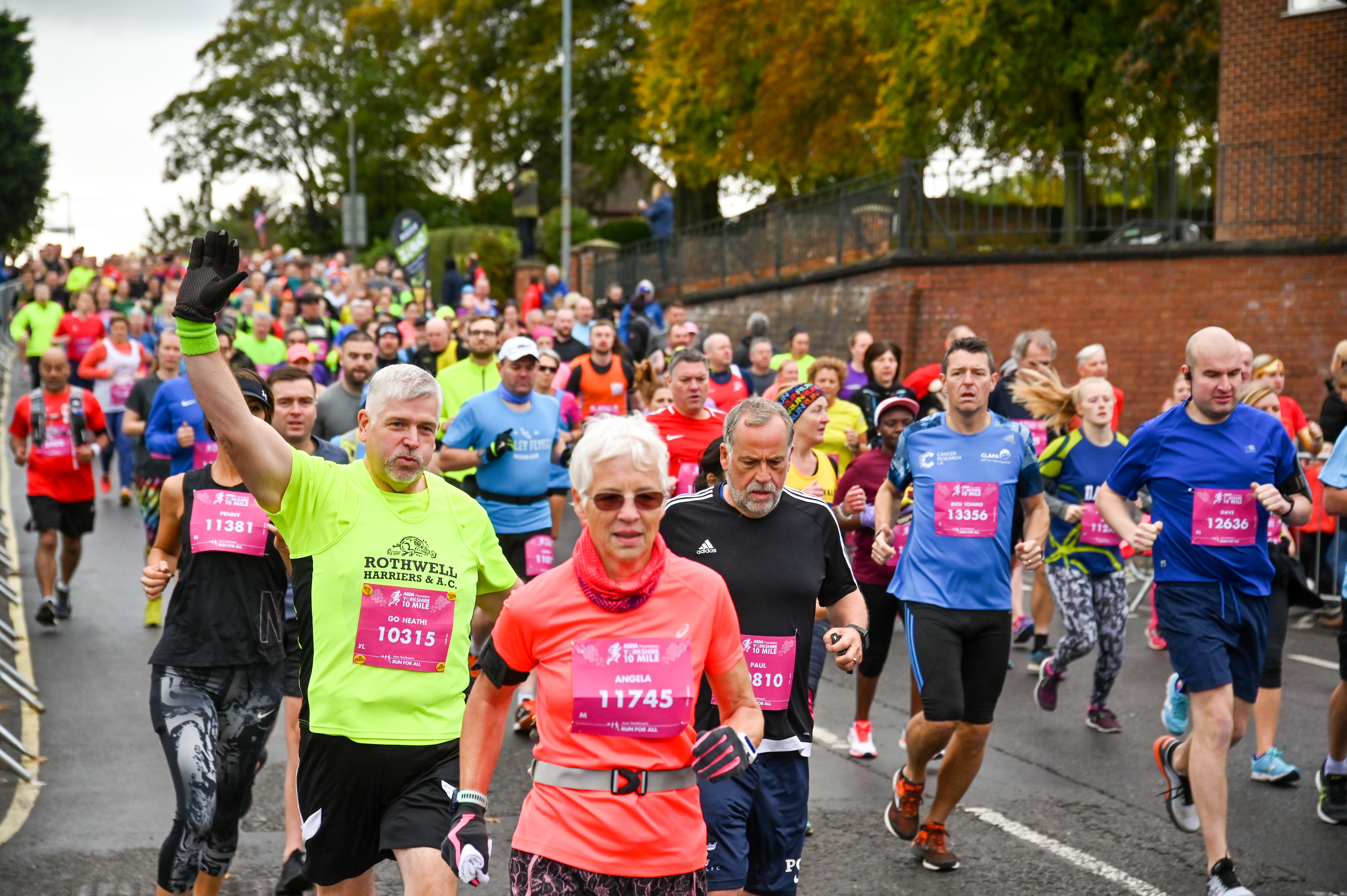 Runners waving while taking part in the Yorkshire Marathon