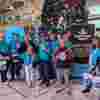 Fight for Sight Christmas Carol Singers and volunteers at Waterloo Station standing in front of a huge Christmas tree