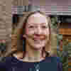 Kate Cameron outside, smiling with her hair swept back by the wind 