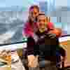 Pat and Laine out together for a meal, Pat is sitting down with Laine standing behind him with her arms around his shoulders
