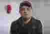 Javid a man of Indian descent in his 40s, he's facing the camera wearing a black shirt and cap.