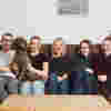 Kate Cameron from the Cameron family fund, plus her four children and their dog, sat smiling together on a brown sofa