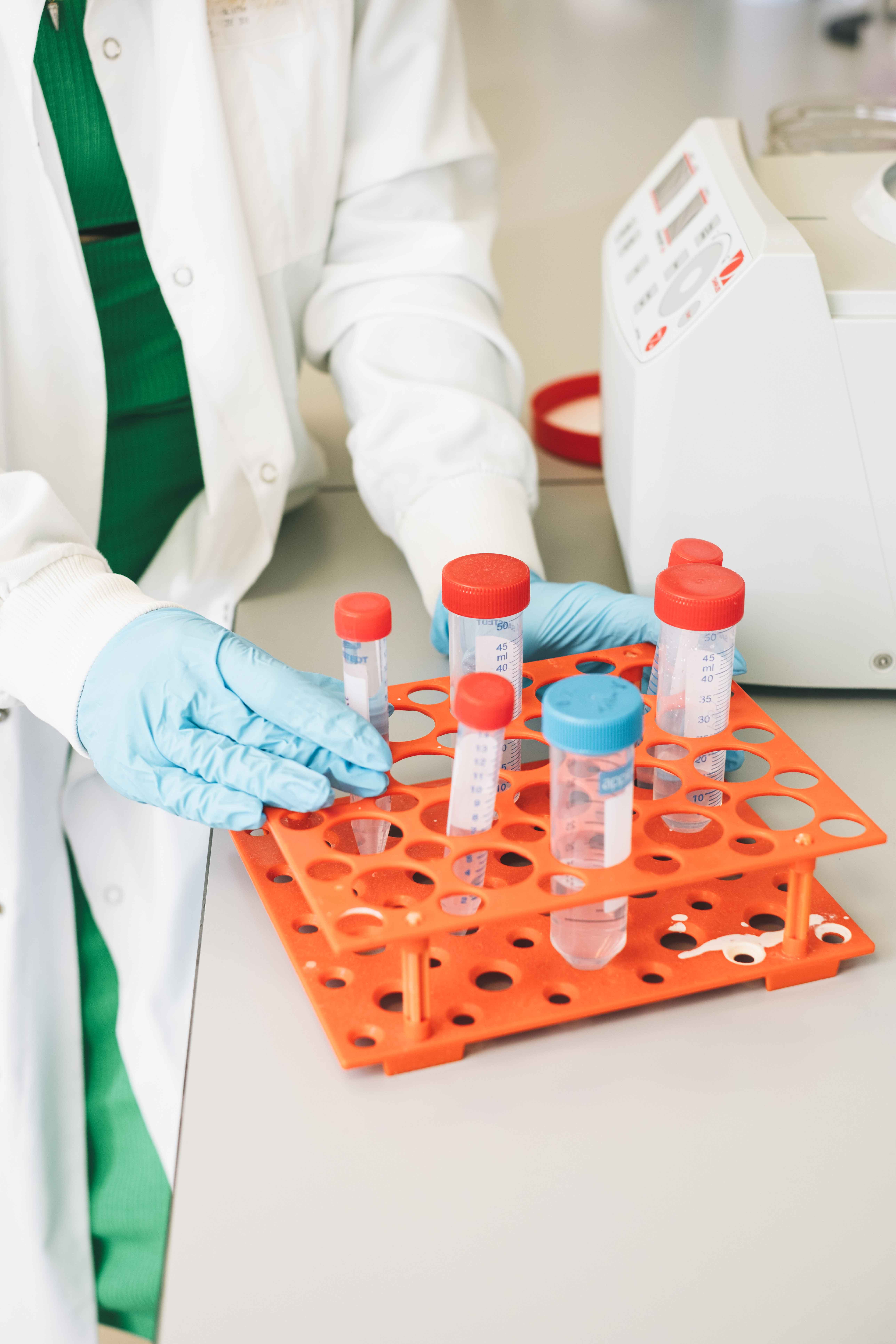 Close up image of a researcher placing test tubes into a rack