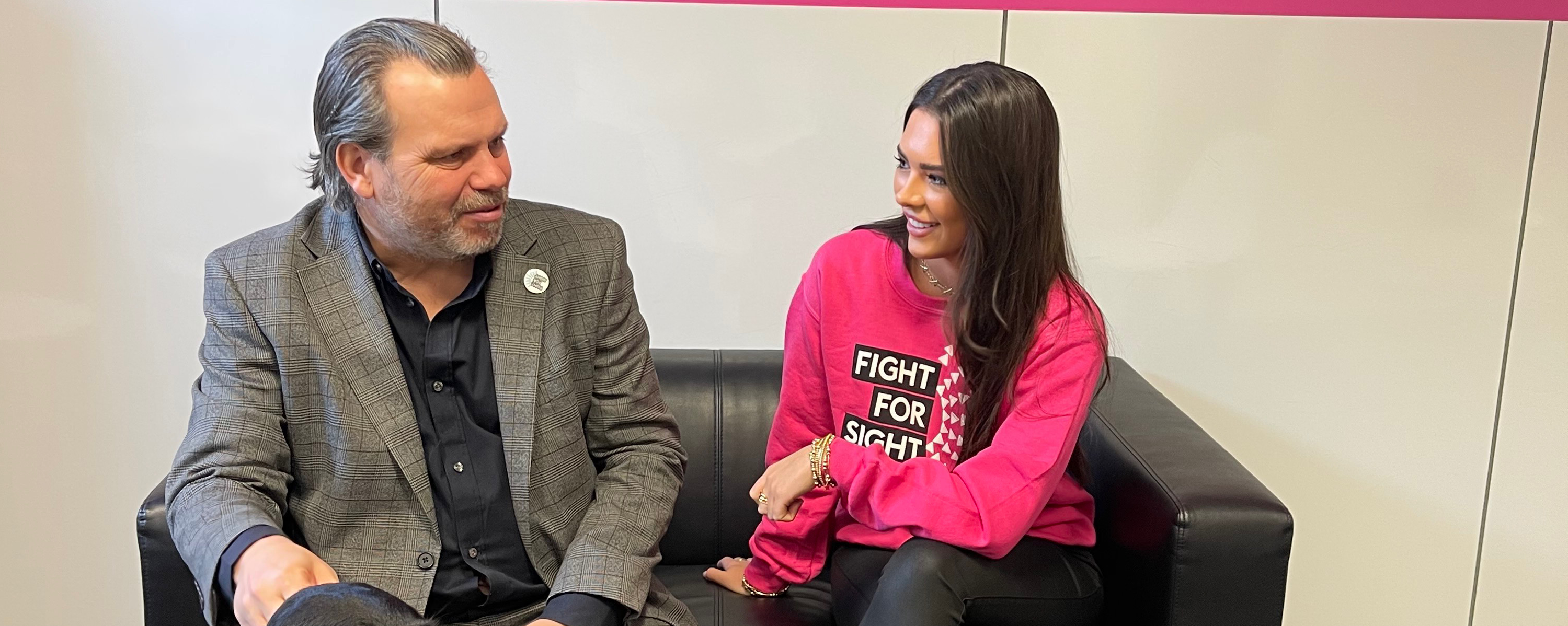 Keith Valentine and Gemma Owen sitting on a sofa.