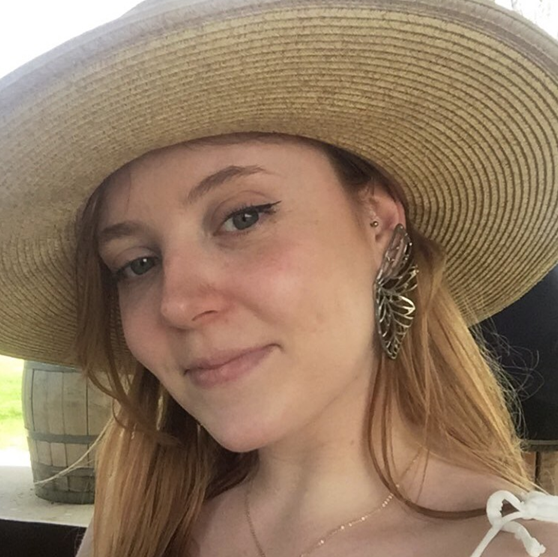 A photo of Lauren in a wide-brimmed straw hat.