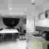A long board room table with a screen and HDMI setup at one end. There is also a kitchenette with a sink and coffee machine.