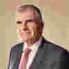 CAF CEO Neil Heslop. He wears a suit jacket, shirt and a tie.
