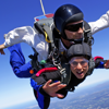 Photo of a man and a woman tandem skydiving
