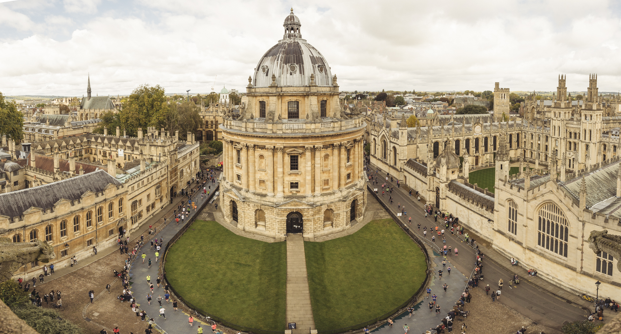 A view of Oxford with historic buildings and runners going through the streets while taking part in the Oxford Half Marathon