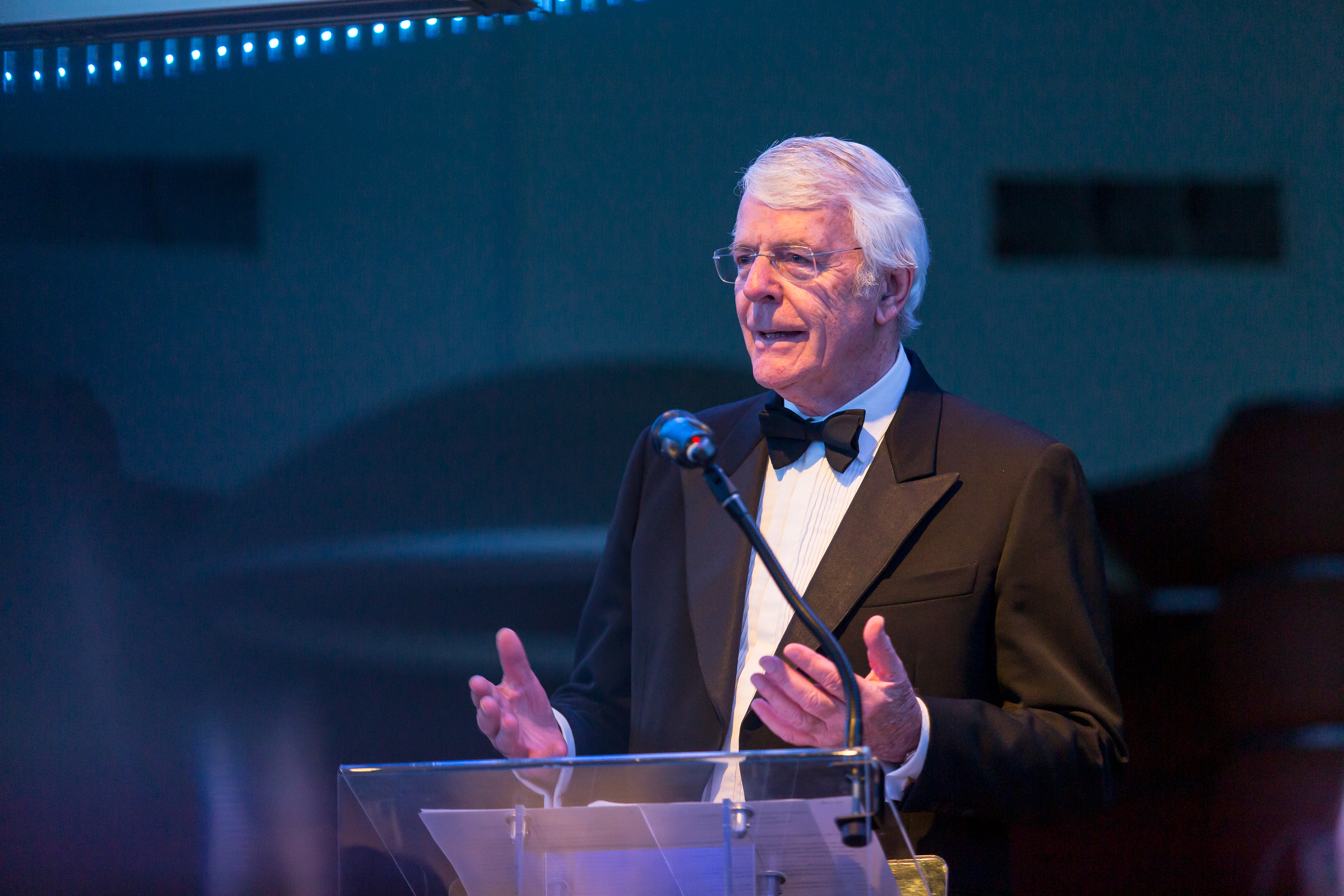 Sir John Major speaking at See my Skills gala 2022 he's standing behind a podium mid-speech wearing a formal suit with a bowtie