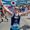 Fight for Sight supporter Will is stretching out his arms to wave to the cheerpoint on Tower Bridge, whilst taking part in the London Marathon