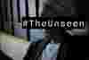 A black woman with a headscarf looks downwards while leaning against a wall, her face is obscured by the words The Unseen