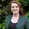 oto of Alison McGovern MP. She is a white woman with reddish hair wearing a green jacket and standing outside.