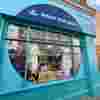 Our Portobello Road Charity Shop - Turquoise signage with a navy semi circle that contains the Fight for Sight name and logo and the words Change Lives.