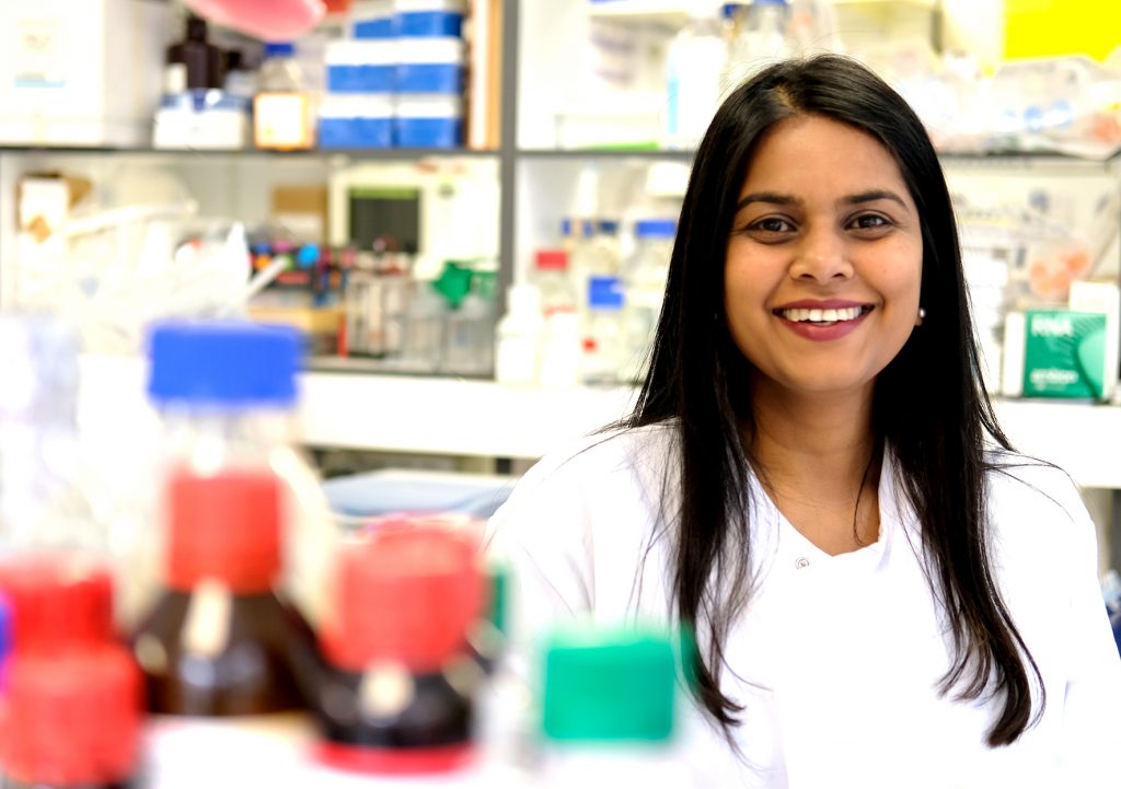 Professor Mariya Moosajee Consultant Ophthalmic Surgeon and Clinical Academic Ophthalmologist  Moorfields Eye Hospital London Great Ormond Street Hospital for Children UCL Institute of Ophthalmology,  in her lab wearing a white coat. 